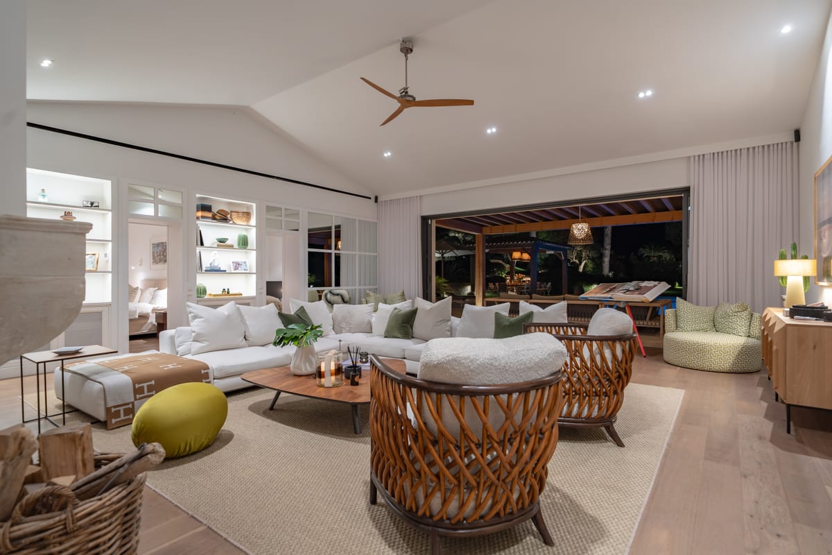 A second sitting room with a vaulted ceiling, deep sofas and a wide opening onto the terrace.